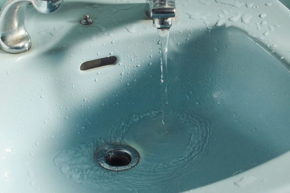 Weak water flow from a bathroom faucet showing low pressure